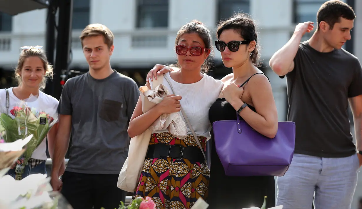 Sejumlah warga mengikuti upacara peringatan setahun serangan teror Jembatan London, di London Bridge, Inggris (3/6). Delapan orang tewas dan hampir 50 lainnya luka-luka akibat serangan yang terjadi setahun lalu itu. (AFP/Daniel Leal-Olivas)