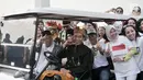 Pasangan capres dan cawapres Joko Widodo-Ma'ruf Amin menaiki mobil golf sambil menunjukkan salam satu jari saat mengikuti pawai Deklarasi Kampanye Damai di Monas, Minggu (23/9). (Merdeka.com/Iqbal Nugroho)