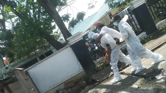 Polisi menggendong pasien suspek COVID-19