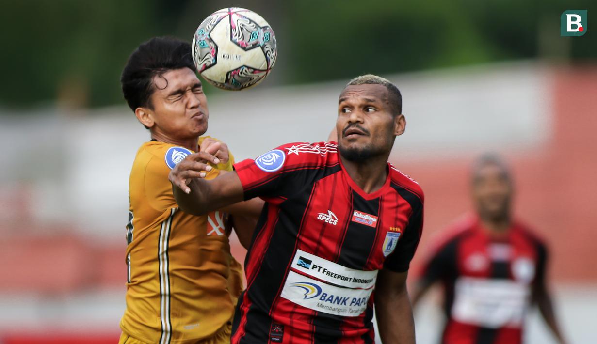 Pemain Persipura Jayapura, Israel Wamiau (kanan) berebut bola dengan pemain Bhayangkara FC, Dendy Sulistyawan dalam laga pekan ke-15 BRI Liga 1 2021/2022 di Stadion Moch. Soebroto, Magelang, Kamis (02/12/2021). (Bola.com/Bagaskara Lazuardi)