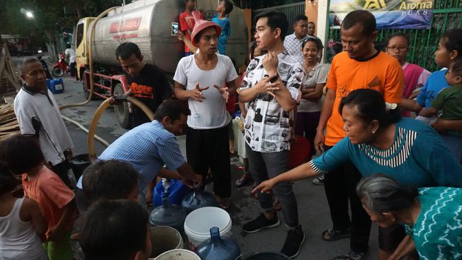 Gibran sedang mengobrol dengan warga saat pemberian bantuan air bersih sebanyak empat mobil tangki air di Kampung Bayan, Jumt (1/11).(Liputan6.com/Fajar Abrori)