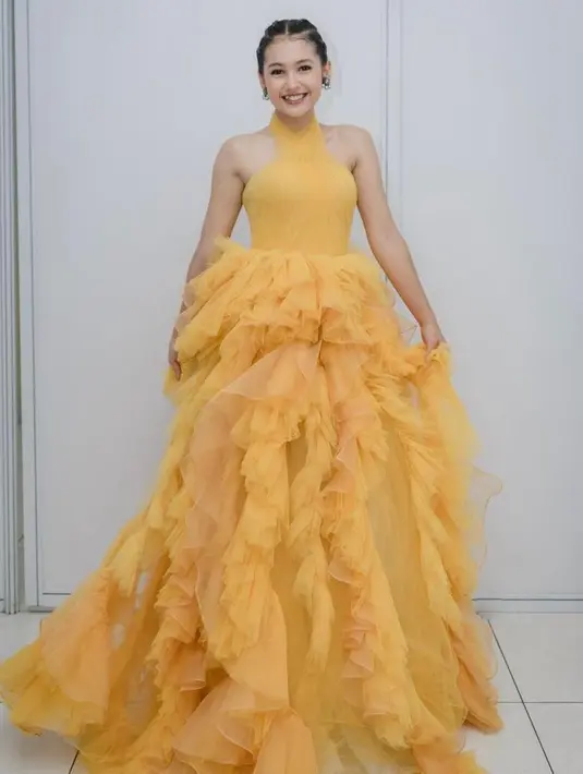 Halter dress berdetail ruffle warna kuning meninggalkan kesan fun dan playful pada penampilan Sandrinna. [@sandrinna_11].