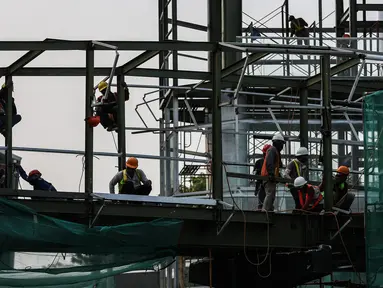 Pekerja menyelesaikan pembangunan halte Centrale Stichting Wederopbouw (CSW) di kawasan Kebayoran Baru, Jakarta, Selasa (8/6/2021). Halte yang akan menghubungkan antar moda transportasi yaitu Transjakarta dengan MRT tersebut mengambil desain Cakra Selaras Wahana. (Liputan6.com/Johan Tallo)