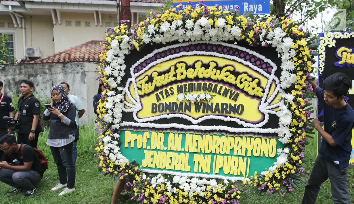 Seorang pria meletakkan karangan bunga duka cita di dekat kediaman Bondan Winarno di kawasan Sentul, Bogor, Rabu (29/11). Tahun ini Bondan telah menjalani dua kali operasi jantung sebelum akhirnya meninggal dunia pagi tadi. (Liputan6.com/Herman Zakharia)