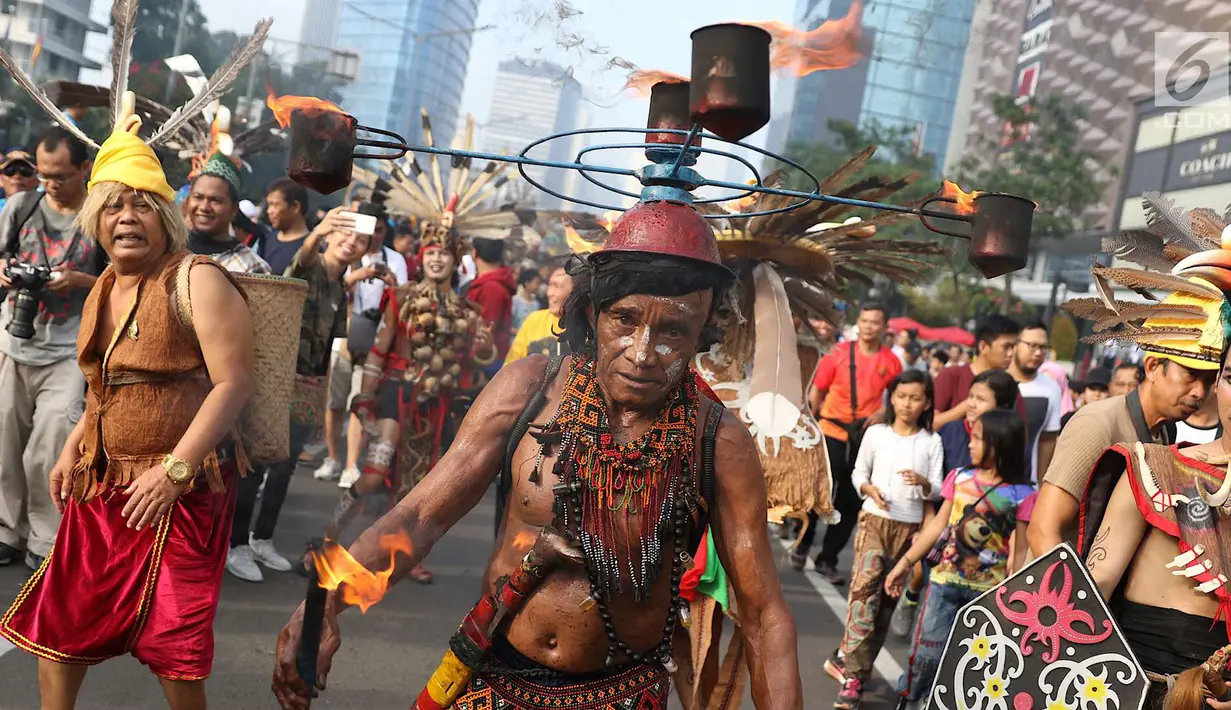 Kelompok seni budaya Kalimantan Selatan berpawai mengenakan pakaian adat saat pelaksanaan car free day di Jakarta, Minggu (1/7). Pawai tersebut diadakan untuk mengenalkan budaya Kalimantan Selatan kepada masyarakat. (Liputan6.com/Immanuel Antonius)