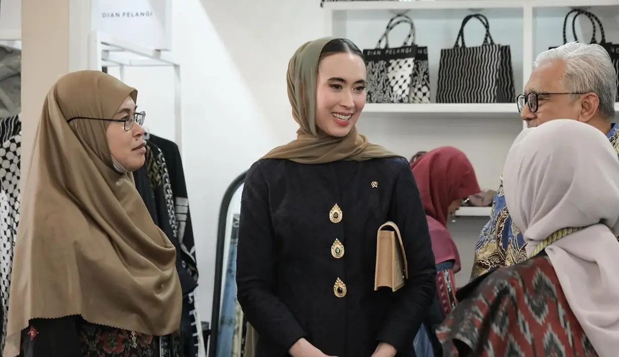 Ia juga kenakan kerudung berwarna hijau olive dan kacamata frame tipis emas andalannya [@widi.wardhana]