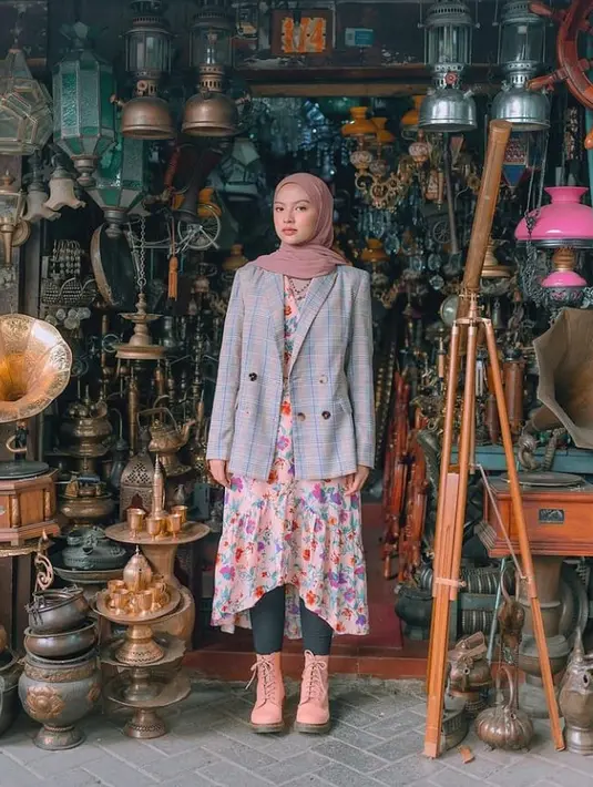 Tampak anggun nan catchy, Tasya Kissty memadukan blazer motif tartan, floral dress, celana legging, dan juga brogue boots. (Instagram/tasyakissty).