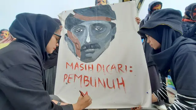 Seniman Arifa Safura dan Alica Putri Anjani melukis dalam aksi menuntut kasus pembunuhan Munir sebagai pelanggaran HAM berat di Simpang Lima, Banda Aceh (Liputan6.com/Rino Abonita)