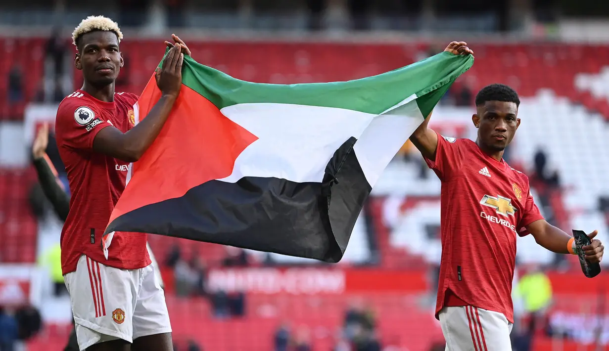 Paul Pogba dan Amad Diallo pun menjadi pesepakbola profesional yang mengekspresikan solidaritas mereka untuk rakyat Palestina. Keduanya memang merupakan pemain Muslim di skuad United. (Foto: AFP/Pool/Laurence Griffiths)