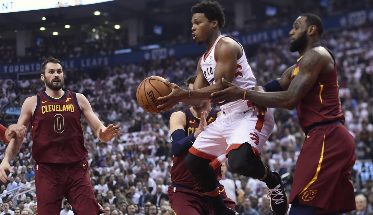 Pemain Raptors, Kyle Lowry (tengah) berusaha melewati adangan dua pemain Cleveland pada laga NBA basketball playoffs Eastern Conference semifinal di Air Canada Centre, (1/2/2018). Cavaliers menang 113-112. (Nathan Denette/The Canadian Press via AP)