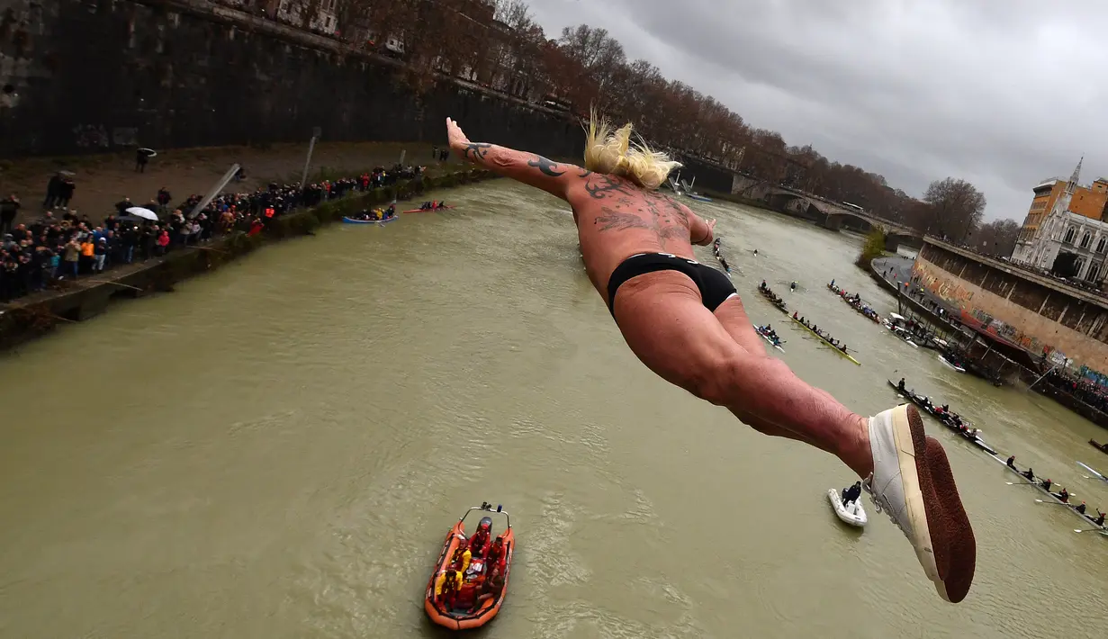 Maurizio Palmulli dikenal sebagai 'Mister OK' melompat ke Sungai Tiber dari Jembatan Cavour di Roma, Selasa (1/1). Masyarakat Italia menandai mulainya tahun 2019 dengan tradisi terjun ke Sungai Tiber dari jembatan setinggi 18 meter . (Alberto PIZZOLI/AFP)