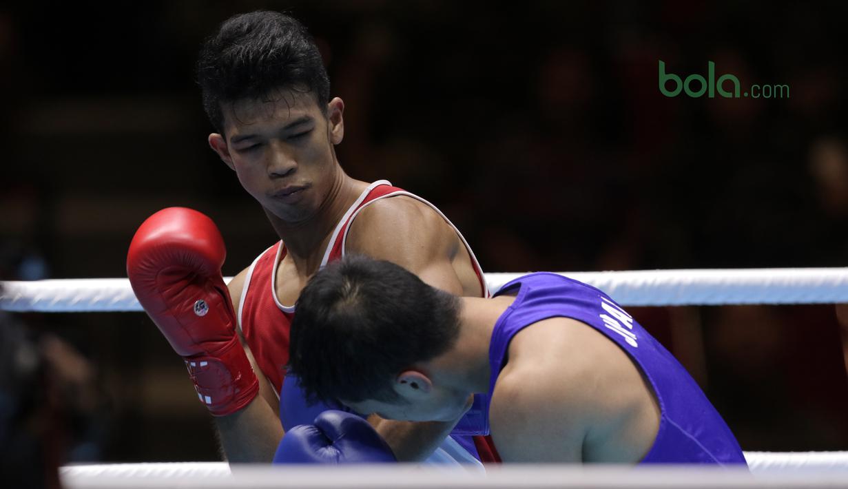 Grece Savon Simangunsong (kiri) melepaskan pukulan ke arah petinju  Jepang, Hiroaki Kinjo pada semifinal Test Event Asian Games 2018 kelas welter di Kemayoran, Jakarta (14/2/2018). Simangunsong menang dengan skor 3-2. (Bola.com/Nick Hanoatubun)