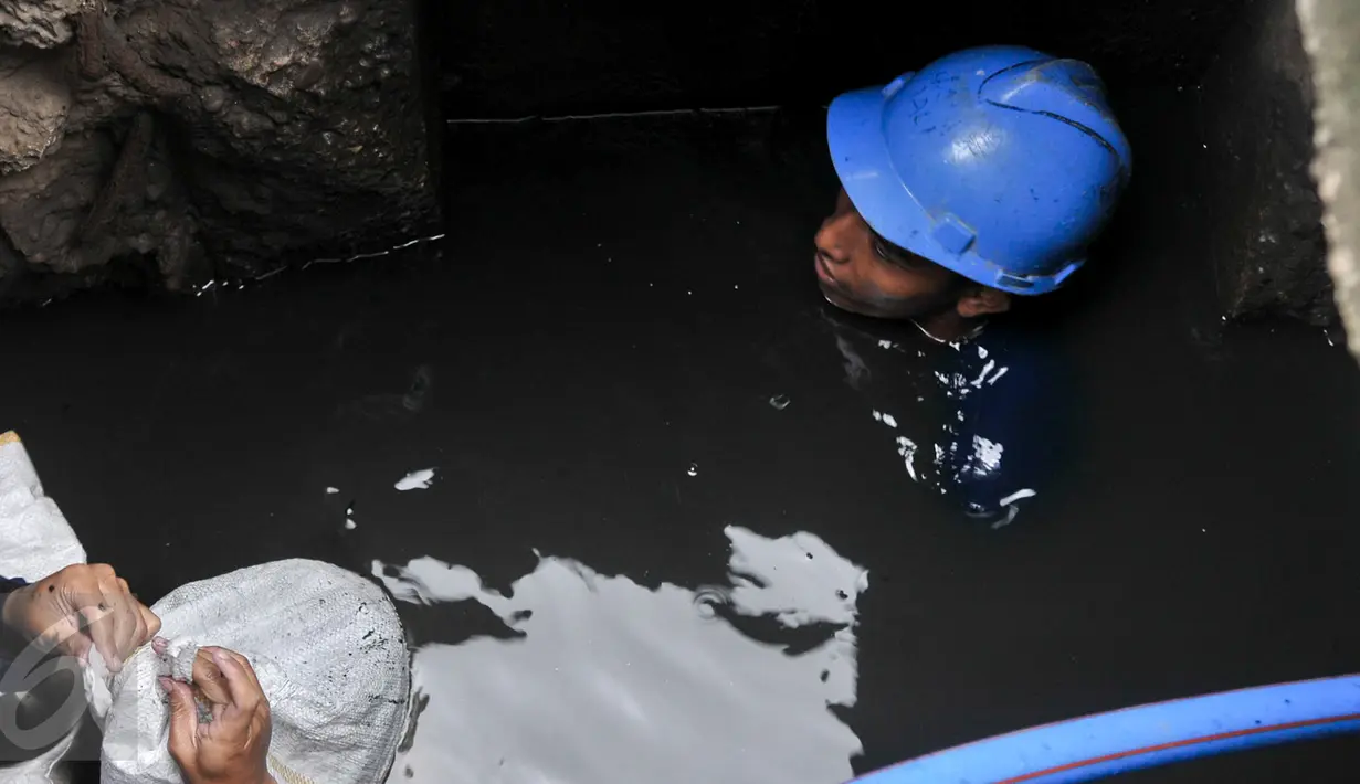 Petugas harian lepas (PHL) Sudin SDA membersihkan endapan pasir dan sampah dalam gorong-gorong di Jalan Gatot Subroto, Jakarta, Jumat (10/3). Pembersihan dilakukan karena di kawasan ini banjir selalu datang saat hujan turun. (Liputan6.com/Yoppy Renato)