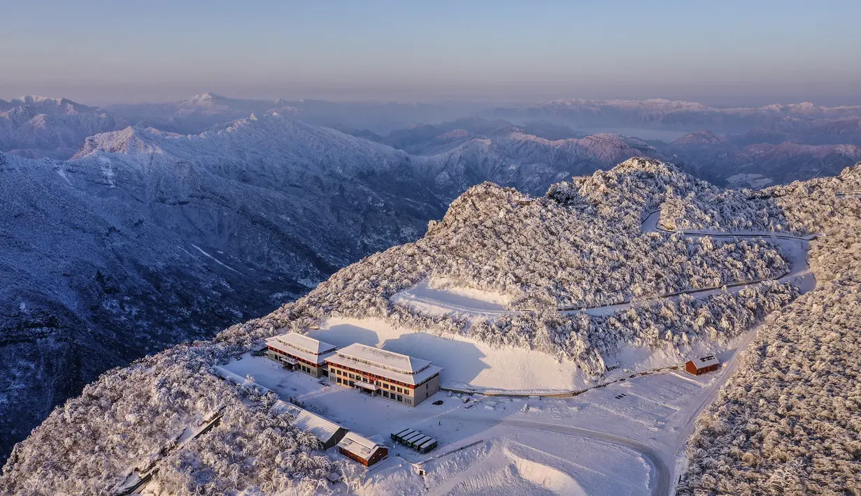 Foto dari udara yang diabadikan pada 20 Desember 2020 ini menunjukkan pemandangan objek wisata Longtoushan saat matahari terbit di Distrik Nanzheng di Hanzhong, Provinsi Shaanxi, China. Saat musim dingin, hamparan salju yang putih menjadi hal yang indah untuk dinikmati. (Xinhua/Tao Ming)