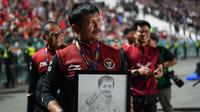 Pelatih kepala Timnas Indonesia U-22, Indra Sjafri memegang gambar dirinya saat merayakan kemenangan pada laga final sepak bola SEA Games 2023 melawan Thailand di Olympic Stadium, Phnom Penh, Kamboja, Selasa (16/05/2023). Skuad Garuda Nusantara menang dengan skor 5-2. (AFP/Nhac Ngyuen)