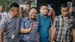 Anggota DPRD Provinsi Jambi Supriyono menyapa awak media saat dibawa ke Gedung KPK, Jakarta, Rabu (29/11). Dalam operasi senyap yang dilakukan KPK kemarin, ada sekitar 11 orang yang diciduk di Jambi dan Jakarta. (Liputan6.com/Faizal Fanani)