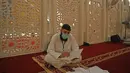 Pria Muslim dengan mengenakan masker saat membaca Alquran saat beritikaf di Masjid Agung Faisal di Islamabad, Pakistan, Kamis (14/5/2020). Itikaf adalah berdiam diri di masjid dengan niat beribadah untuk mendekatkan diri kepada Allah swt pada sepuluh hari terakhir bulan Ramadan. (Aamir QURESHI/AFP)