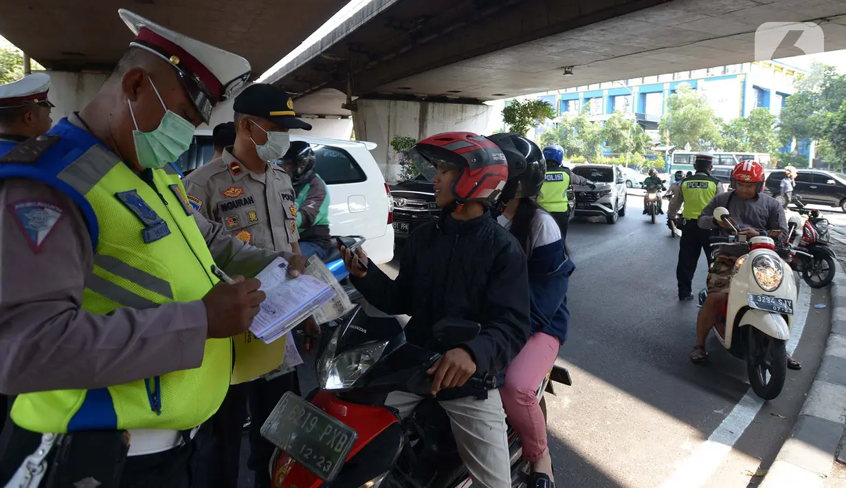 Polisi menilang pengendara motor saat Operasi Zebra Jaya 2019, Jakarta Barat, Jumat (1/11/2019). Operasi Zebra Jaya digelar hingga 5 November 2019. (merdeka.com/Imam Buhori)