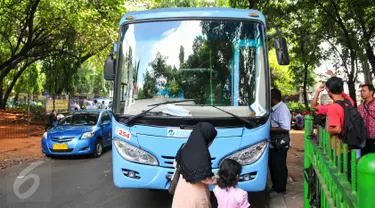 Penumpang saat akan menaiki feeder bus Transjakarta di Stasiun Tebet, Jakarta, Kamis (7/4). Armada itu dikerahkan untuk mengantisipasi penumpukan penumpang saat perlintasan KRL Tebet ditutup. (Liputan6.com/Yoppy Renato)