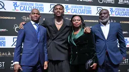 Pemain AC Milan, Rafael Leao (kedua kiri) berpose dengan sejumlah anggota keluarganya saat menghadiri Italian Footballers Association (AIC) Awards 2023 di Milan, Italia, Selasa (05/12/2023) WIB. (AFP/Marco Bertorello)