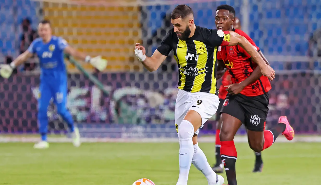 Pemain Al Ittihad, Karim Benzema, menggiring bola saat melawan Al Riyadh pada laga pekan ketiga Liga Arab Saudi di Prince Faisal bin Fahd Stadium, Riyadh, Jumat (25/8/2023). Benzema sukses menyumbang satu gol ketika Al Ittihad pesta gol ke gawang Al Riyadh. (AFP/Fayez Nureldine)