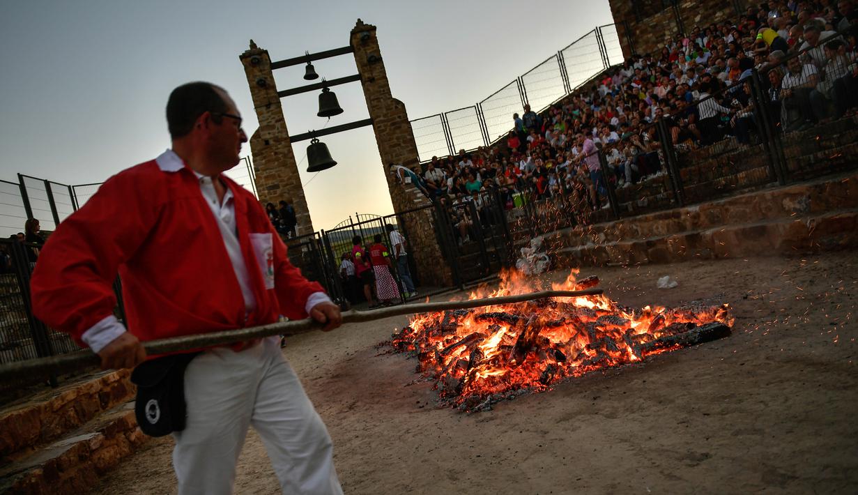 Seorang pria menyiapkan kayu bakar sebelum perayaan malam San Juan di San Pedro Manrique, Spanyol Utara, Minggu (24/6). Tradisi kuno Spanyol ini diperingati untuk menyambut musim panas. (AP Photo/Alvaro Barrientos)