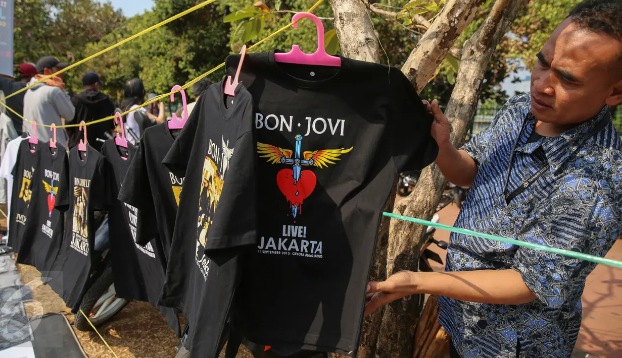 Pengunjung melihat kaos Bon Jovi yang dijajakan pedagang di luar Stadion Gelora Bung Karno, Jakarta, Jumat (11/9/2015). Grup band asal Amerika itu akan menggelar konser ‘Bon Jovi Live! Jakarta' nanti malam di arena GBK. (Liputan6.com/Faizal Fanani)