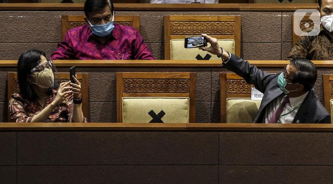 Menteri Keuangan Sri Mulyani (kiri) bersama Menteri Hukum dan HAM Yasonna Laoly (kanan) saat mengikuti Rapat Paripurna di Kompleks Parlemen, Jakarta (5/10/2020).Rapat membahas berbagai agenda, salah satunya mengesahkan RUU Omnibus Law Cipta Kerja menjadi UU. (Liputan6.com/JohanTallo)