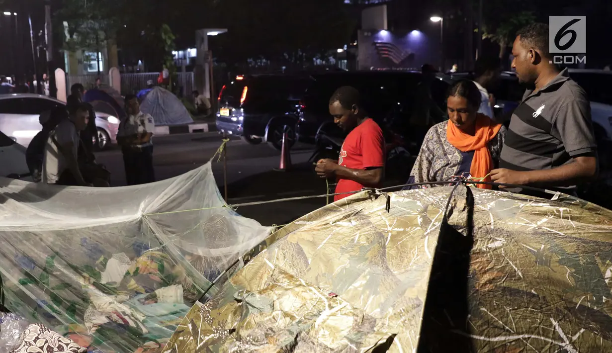 Pencari suaka mendirikan tenda untuk beristirahat di atas trotoar depan kantor UNHCR, Jalan Kebon Sirih, Jakarta, Jumat (5/7/2019). Para pencari suaka ini membangun tenda-tenda dan meminta kepastian perlindungan dari UNHCR . (Liputan6.com/Helmi Fithriansyah)