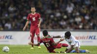 Gelandang Timnas Indonesia, Evan Dimas, dijatuhkan pemain Malaysia pada semifinal SEA Games di Stadion Shah Alam, Selangor, Sabtu (26/8/2017). Indonesia kalah 0-1 dari Malaysia. (Bola.com/Vitalis Yogi Trisna)