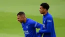 Pemain Paris Saint-Germain Kylian Mbappe (kiri) tertawa bersama Hugo Ekitike saat sesi latihan di tempat latihan klub di Saint-Germain-en-Laye, Prancis, Selasa (13/9/2022). Paris Saint-Germain (PSG) akan melawan Maccabi Haifa pada pertandingan sepak bola putaran pertama Grup H Liga Champions. (FRANCK FIFE/AFP)