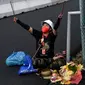 Seorang pawang hujan melakukan ritual saat sesi latihan bebas MotoGP Indonesia di Sirkuit Mandalika, Mandalika, Lombok Tengah, Nusa Tenggara Barat, Jumat (18/3/2022). (AFP/Bay Ismoyo)