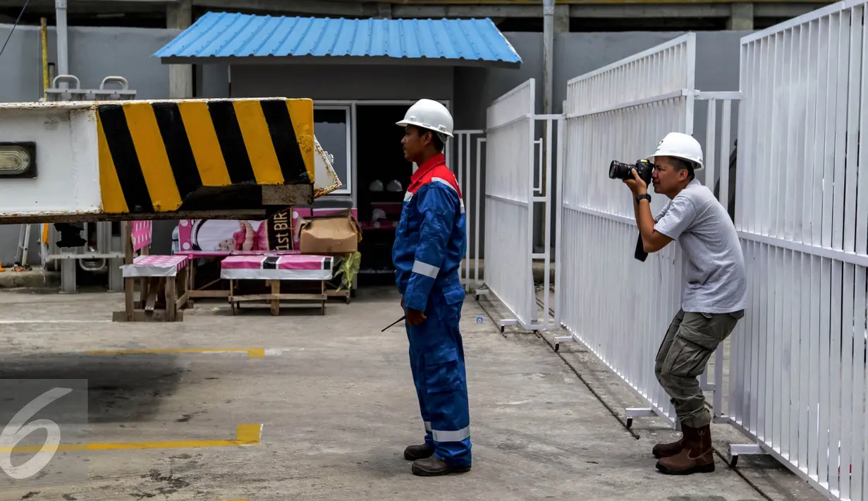 Seorang jurnalis foto mengabadikan petugas Pertagas Niaga yang akan menyuplai LNG untuk pusat perbelanjaan Balcony di Balikpapan, Kalimantan, Kamis (14/05). (Liputan6.com/Fery Pradolo)