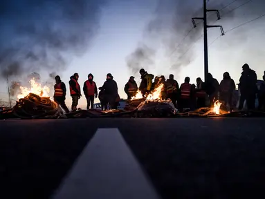 Puluhan anggota serikat pekerja memblokir jalan di depan kilang Total Energies dalam sebuah aksi yang diserukan oleh serikat pekerja Konfederasi Umum Buruh Prancis (CGT) untuk menentang perombakan dana pensiun yang sangat tidak populer di Donges, Prancis Barat, Rabu (8/2/2023). Prancis bersiap menghadapi pemogokan baru dan demonstrasi massal menentang proposal Presiden Prancis untuk mereformasi pensiun Prancis, termasuk menaikkan usia pensiun dari 62 menjadi 64 tahun. (LOIC VENANCE/AFP)