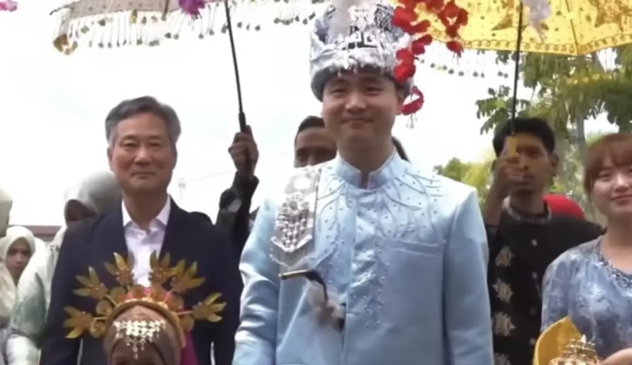 <p>Song Hyeok pun lengkap mengenakan tutup kepala Meukeutop, dengan menggendeng ke dua anak kecil yang mengenakan pakain adat Aceh.&nbsp; [Instagram/@kimgunwoooooo]</p>