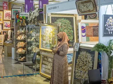Seorang wanita berdiri di depan salah satu stan pada pameran kerajinan Inacraft 2022 di Balai Sidang Jakarta Convention Center (JCC), Rabu (23/3/2022). Penyelenggaraan Inacraft ke-22 ini mengusung tema “Smiling Heritage of West Java; From Smart Village to Global Market”. (Liputan6.com/Faizal Fanani)