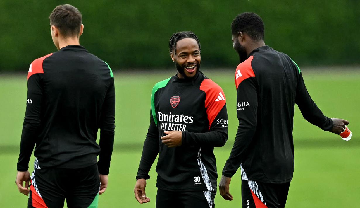 Pemain Arsenal, Raheem Sterling berbincang dengan rekan setimnya saat latihan menjelang laga lanjutan Liga Champions melawan PSG di Arsenal Training Centre, Hertfordshire, Inggris, Selasa (01/10/2024). (AFP/Glyn Kirk)