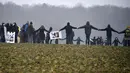 Aktivis anti-nuklir membuat lingkaran saat melakukan aksi demonstrasi di Mandres-en-Barrois, Prancis (3/3). Para aktivis ini menggelar aksi untuk menolak pembuangan limbah nuklir di hutan Lejuc. (AFP Photo/Jean Christope Verhaegen)