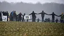 Aktivis anti-nuklir membuat lingkaran saat melakukan aksi demonstrasi di Mandres-en-Barrois, Prancis (3/3). Para aktivis ini menggelar aksi untuk menolak pembuangan limbah nuklir di hutan Lejuc. (AFP Photo/Jean Christope Verhaegen)