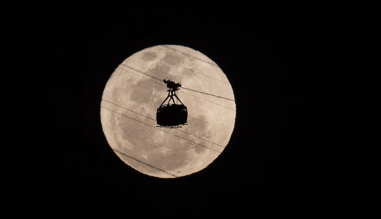 Kereta gantung menuju Gunung Sugarloaf bulan purnama terbesar atau supermoon muncul di langit malam di Rio de Janeiro, Brasil pada Senin, 19 Agustus 2024. (AP Photo/Bruna Prado)