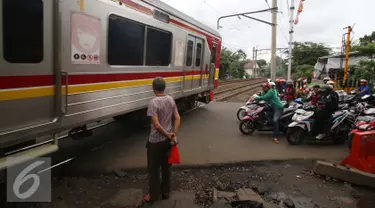 Sebuah kereta Commuter Line melintas di perlintasan kereta api Bintaro, Jakarta, Senin (16/1). Untuk mengurangi angka kecelakaan di perlintasan kereta api, Pemerintah Provinsi DKI Jakarta akan membangun jalan layang. (Liputan6.com/Gempur M. Surya)