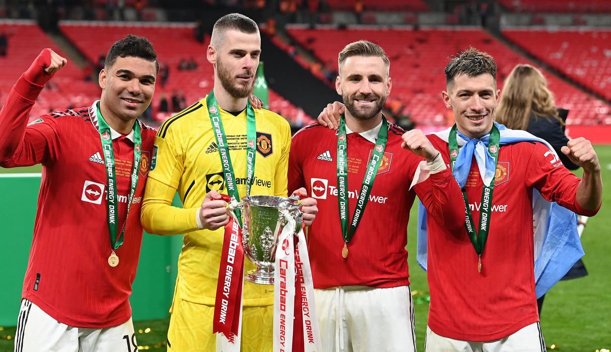 Kiper Manchester United, David de Gea (kedua kiri) bersama rekannya berpose dengan trofi Carabao Cup setelah memenangkan laga final melawan Newcastle United di Stadion Wembley Stadium, London, 26 Februari 2023. Ini merupakan trofi kedua Carabao Cup yang pernah dipersembahkan De Gea saat berseragam MU. Sebelumnya, Ia pernah merebut trofi tersebut pada musim 2016/2017. (AFP/Glyn Kirk)