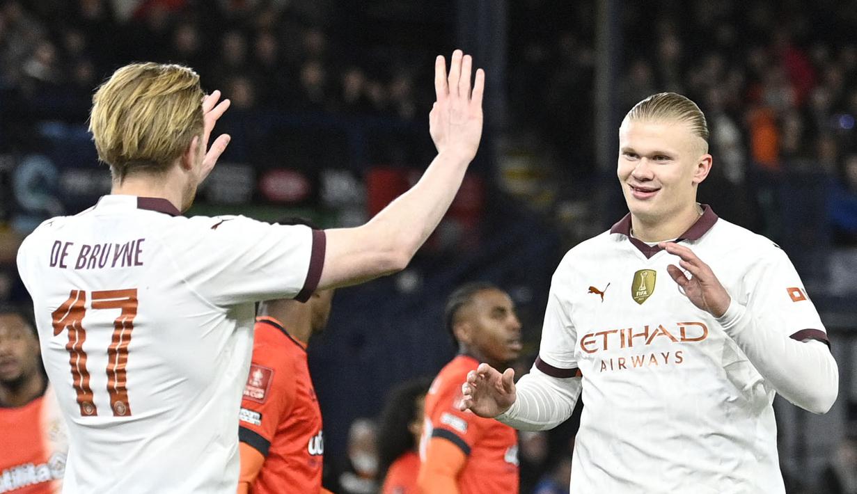 Pemain Manchester City, Erling Haaland (kanan) melakukan selebrasi bersama Kevin De Bruyne setelah mencetak gol ke gawang Luton Town pada laga putaran kelima Piala FA 2023/2024 yang berlangsung di Kenilworth Road Stadium, Luton, Inggris, Rabu (28/02/2024) dini hari WIB. (AFP/Justin Tallis)