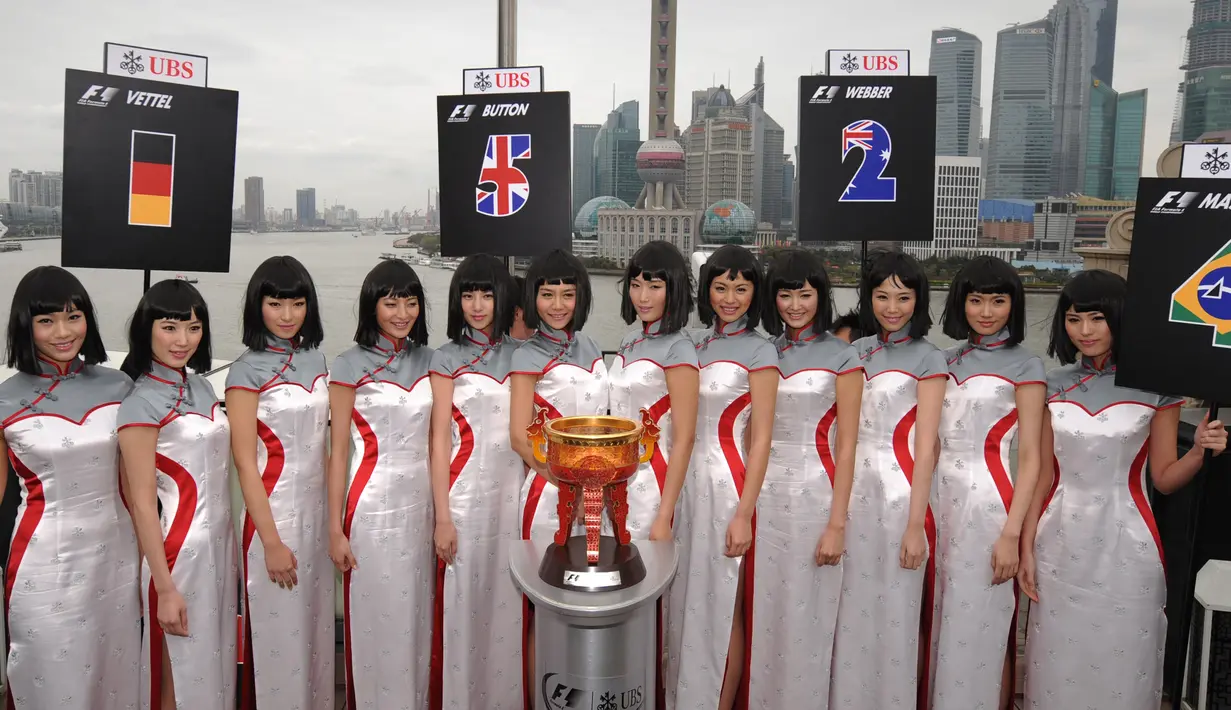 Gadis Grid atau Grid Girls berpose di belakang piala pemenang untuk Grand Prix Formula 1 China di Sanghai (26/3/2013). Grid Girls akan dihapus saat seri pertama F1 di Melbourne, Australia Maret 2018. (AFP FOTO / Tam Peterja)