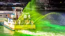 Petugas menggunakan kapal untuk menyemprotkan pewarna  hijau khusus ke sungai Chicago, AS selama perayaan St. Patrick's Day, 11 Maret 2017. Sungai itu setiap tahun mengalami perubahan warna demi memikat wisatawan. (Maria Cardona /Chicago Tribune via AP)