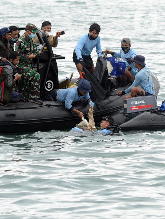 Tim SAR mengevakuasi potongan pesawat Sriwijaya Air SJ 182 di perairan Kepulauan Seribu, Jakartra, Minggu (10/1/2021). Sriwijaya Air SJ 182 hilang kontak empat menit usai lepas landas dari Bandara Soetta. (merdeka.com/Arie Basuki)