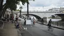 Orang-orang menikmati tepian Sungai Seine di Paris, Prancis, Minggu (11/7/2021). Prancis telah mengakhiri kewajiban mengenakan masker di luar ruangan dan pencabutan jam malam sejak pertengahan Juni lalu menyusul penurunan kasus COVID-19. (AP Photo/Lewis Joly)