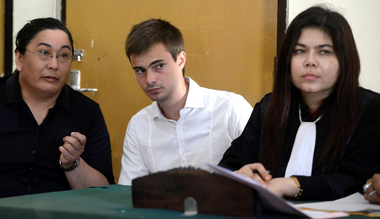 Antony Lambert berbincang dengan kuasa hukumnya saat menjalani persidangan di pengadilan Denpasar, Bali, Indonesia (14/9). Pria 23 tahun ini ditangkap saat tiba di Bali dari Kuala Lumpur pada bulan Juni. (AFP Photo/Sony Tumbelaka) 