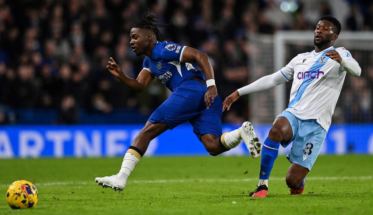 Gelandang Chelsea asal Belgia, Romeo Lavia (kiri) menjadi pemain termuda yang diturunkan The Blues saat menang 2-1 atas Crystal Palace. Umurnya baru menginjak 19 tahun, 11 bulan dan 21 hari dalam laga tersebut. Dalam laga debutnya bersama Chelsea di Premier League sekaligus di semua ajang tersebut ia bermain selama 32 menit setelah baru dimasukkan pada menit ke-58 menggantikan Ian Maatsen. (AFP/Glyn Kirk)