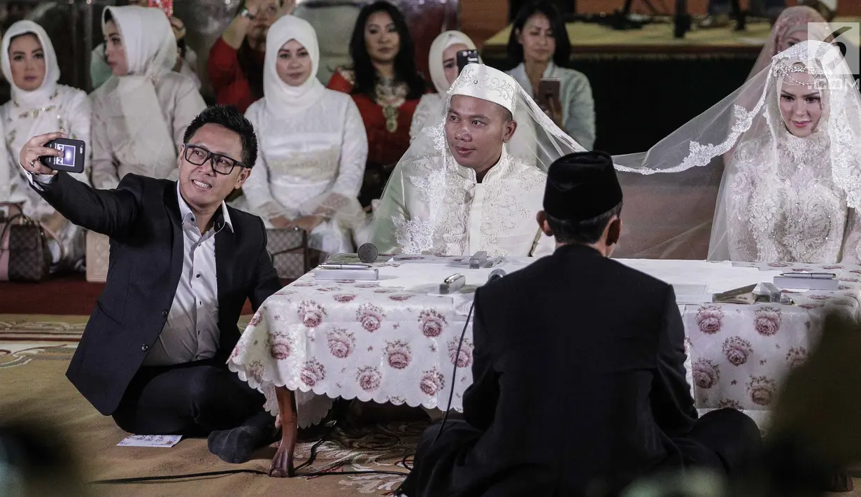 Artis Eko Hendro Purnomo (Eko Patrio) berswafoto dengan pasangan pengantin Vicky Prasetyo dan  Angel Lelga saat akad nikah di Mesjid Istiqlal, Jakarta, Jumat (9/2). Eko Patrio menjadi saksi pernikahan Vicky dan Angel. (Liputan6.com/Faizal Fanani)